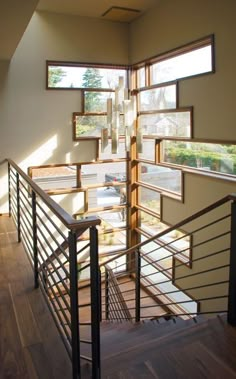 an open stairwell with wooden handrails and windows