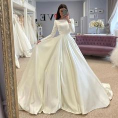 a woman is taking a selfie in her wedding dress while standing in front of a mirror