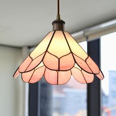 a lamp hanging from the ceiling in front of a window