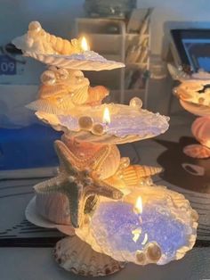 three seashells with candles in them on a table