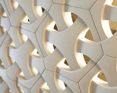 a close up view of a decorative wall made out of white tiles with holes in the middle