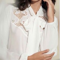 White Blouse With Embroidered Details By Decote Dlx. 100% Polyester Made In Brazil Chic Embroidered Daywear Blouse, Chic Daywear Blouse With Floral Embroidery, Chic Blouse With Floral Embroidery For Daywear, White Feminine Tie Neck Blouse, Feminine White Tie Neck Blouse, Chic White Embroidered Blouse, Chic Embroidered Workwear Tops, Chic Embroidered Tops For Work, Elegant Floral Embroidered Collar Top