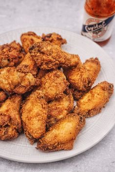 fried chicken on a white plate next to ketchup and mayonnaise bottle