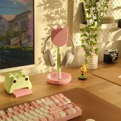 a computer keyboard sitting on top of a wooden desk next to a potted plant