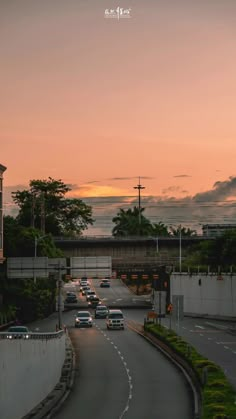 cars are driving down the road at sunset