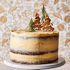 a cake with frosting and decorated trees on top