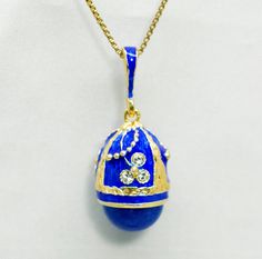 "Miniature 3 D egg pendant, enameled over solid sterling silver, created in our NJ shop in the tradition and spirit of Faberge jewelry.  10 mm lapis stone is set at the bottom of the pendant and clear high quality crystals decorate the floral ornament . The pendant is about 0.7\" ( 19 mm ) without a bail, 1.1\" ( 30 mm ) including the bail . It comes with 18\" sterling silver gold plated chain and in a gift box. If you feel that you need a longer chain, please, contact us, or request it during p Blue Jewelry With Large Pendant For Formal Occasions, Blue Enamel Jewelry For Anniversary, Blue Jewelry With Large Pendant As Gift, Handmade Enamel Jewelry For Formal Occasions, Blue Teardrop Pendant Jewelry For Formal Occasions, Traditional Enamel Necklaces For Formal Occasions, Blue Polished Jewelry As Gift, Traditional Gold Jewelry With Lapis Lazuli, Traditional Engraved Blue Jewelry