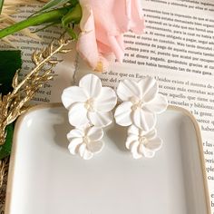 three white flowers sitting on top of a book