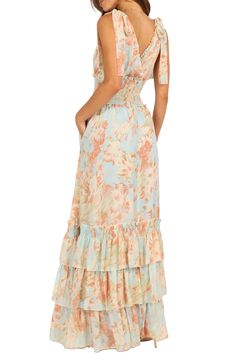 This elegant tie-strap maxi is designed in romantic blooms and centered with a shaping smocked waist. Its flowy skirt is accented with frothy tiered ruffles for an enchanting silhouette. Surplice V-neck Tie straps Sleeveless Smocked waist Lined 100% polyester Hand wash, dry flat Imported Pink And Blue Floral Dress, Floral Print Maxi Dress With Ruffled Straps For Vacation, Feminine Maxi Dress With Ruffled Straps For Beach, Ruched Maxi Sundress For Garden Party, Spring Maxi Dress With Ruched Ruffled Straps, Feminine Beach Maxi Dress With Tie Straps, Feminine Tie Straps Maxi Dress For Beach, Strapless Maxi Dress With Smocked Bodice For Spring, Spring Maxi Dress With Ruched Details And Ruffled Straps