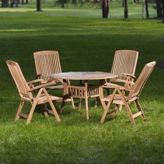 a wooden table and chairs sitting in the grass