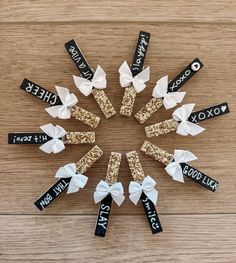 six black and white bows are arranged in the shape of a snowflake with name tags