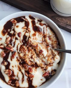 a bowl filled with yogurt and granola next to a glass of milk