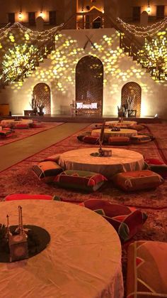 tables and chairs are set up in the middle of a room with lights on it