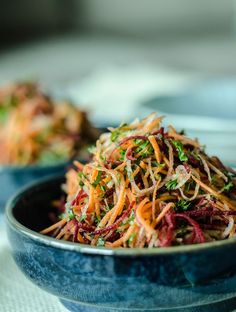 a blue bowl filled with shredded carrots on top of a table