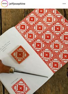 a person using a pair of scissors to cut paper with red and white designs on it