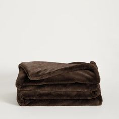 two blankets folded on top of each other, one is brown and the other is black