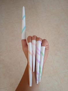 three different colored paper straws are in the palm of a person's hand