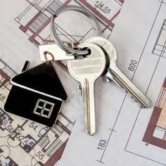 a house shaped keychain sitting on top of a blueprint