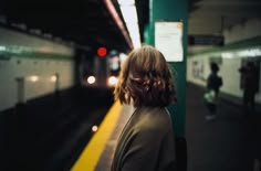 a woman is waiting for the train to arrive