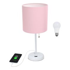 a pink lamp next to a charger with a phone plugged into the light