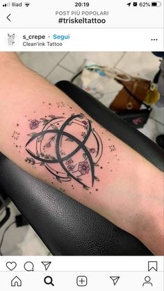 a person with a tattoo on their arm that has an intertwined knot and flowers