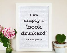 a framed book page with the words i am simply a book drunk on it next to a potted plant