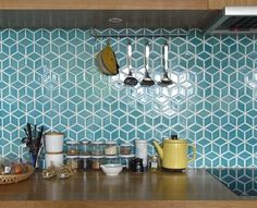 a kitchen counter with bowls and plates on it, next to cupboards filled with utensils