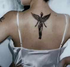 a woman with a cross tattoo on her back