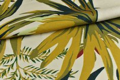 a close up view of a yellow and green tropical print fabric with leaves on it