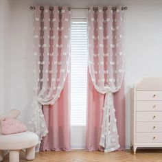 a baby's room with pink curtains and white furniture