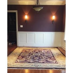 an empty room with purple walls and white paneling on the wall, carpeted floor