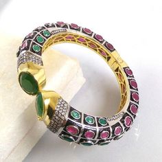 This Listing is for 1 Piece Beautiful Red Aventurine,Green Onyx & CZ Hydro Gemstone 24k Gold Plated Cuff Bangle Bracelet Jewelry Gemstone: Red Aventurine,Green Onyx & CZ Metal : Brass Style : Cuff Bracelet Size : Cuff Adjustable Size Plating : 24k Gold Plated & Black Oxidize Color : Green,Yellow,White,Red Note : We Ship Parcel Via India Post Economy Shipping It's Take 20 To 25 Days To Arrive. Check my other items frequently. I will be adding to the inventory regularly. Be sure to vis Multicolor Stone Set Bangle Bracelets, Multicolor Stone Setting Bangle Bracelet, Unique Stone Bangle Bracelet, Fusion Style Jeweled Bracelets As Gift, Unique Jeweled Bangle Bracelets, Handmade Ruby Bangle Bracelet, Festive Gemstone Bangle Bracelets, Jeweled Bangle Cuff Bracelet As Gift, Jeweled Cuff Bangle Bracelet For Gift