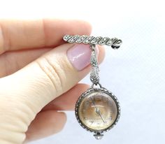 Very unique watch. Round Bubble watch hanging from a brooch/pin. Made by Bucherer. Case and brooch are sterling silver set with marcasite. Condition: Sterling has vintage patina. Watch works, ticks and keeps time. Will need daily winding. Details: 13.1 grams 20.5mm bubble case 48mm dangle Antique Silver Brooch Jewelry, Antique Silver Jewelry Brooch, Timeless Silver Jewelry With Clasp, Antique Silver Brooch For Formal Occasions, Antique Silver Brooches For Formal Occasions, Silver Brooch For Evening Jewelry, Silver Costume Jewelry Brooch For Formal Occasions, Silver Costume Jewelry Brooches For Formal Occasions, Vintage Silver Brooch Jewelry