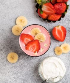 strawberries, bananas and yogurt are on the table