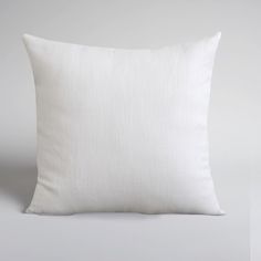 a white pillow on a gray background with no one in the photo to describe it