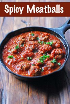 a skillet filled with meatballs on top of a wooden table