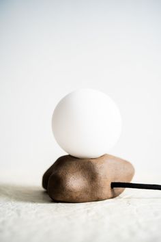 an egg is sitting on top of a rock with a black cord in front of it