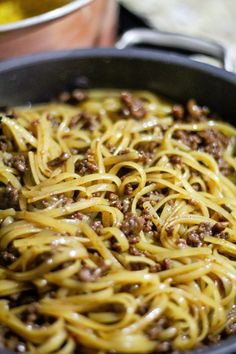 a pan filled with noodles and meat on top of a stove