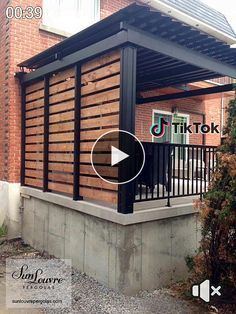 an outdoor covered patio with black railings and wood slats on the side of it