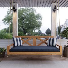 a wooden porch swing with cushions on it