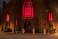 a large building with red lights on it's windows and the words salem witch museum