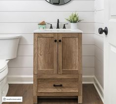 a bathroom with a sink, mirror and wooden cabinet in it's center area