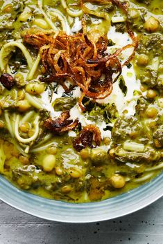 a bowl filled with green soup and noodles