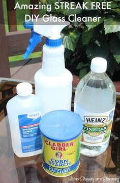 bottles of cleaner and other cleaning products sitting on a table next to a potted plant