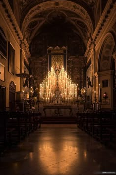 the interior of a church with candles lit up