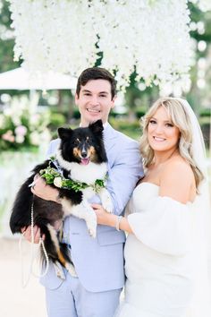 a bride and groom pose with their dog