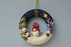 an ornament hanging on the wall with a snowman