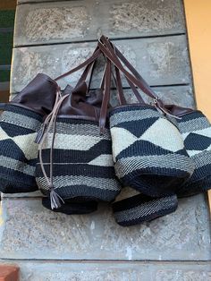 "A beautiful brown and white handbag with leather draw material and handles perfect for all day activities. Dimensions 8\" Kiondo overview A beautiful Multicolored hand bag made of fine weave sisal. It has a zipper and lining. The bag is made of sisal fiber that is hand picked hand prepared into yearn then twisted and weaved. It is finished with natural leather mainly from cow hide. Uses Day out: Its a great bag for use in carrying personal effects such as outdoor mats ,sandals and other picnic Handwoven Leather Bucket Bag, Bohemian Pouch Bucket Bag With Leather Handles, Daily Use Straw Pouch Bag With Leather Handles, Bohemian Crochet Bucket Bag With Leather Handles, Brown Crochet Bag With Leather Top Handles, Brown Bohemian Bucket Bag, Brown Crochet Top Handle Bag With Leather Handles, Bohemian Bucket Bag With Leather Handles For Shopping, Leather Bucket Straw Bag For Market