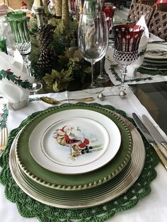 a table set for christmas dinner with plates, silverware and napkins on it