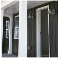 two lights on the side of a house next to an open door and another window